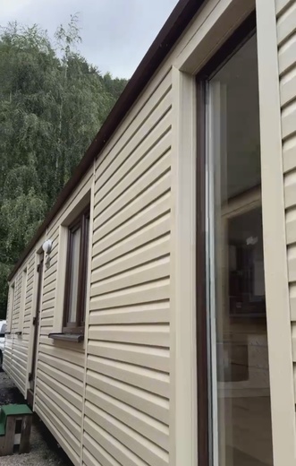 Biely mobilný dom – hnedé okná, čelný pohľad moderného domu