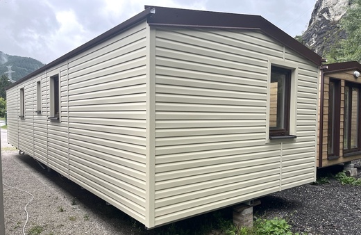 Mobilný dom – biely s hnedými oknami a hnedou strechou