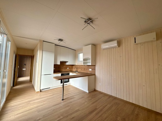 Interiér mobilného domu Family – obývačka s kuchyňou a dreveným obkladom